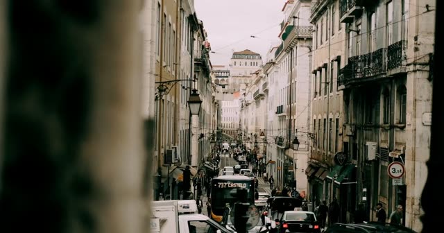 A long Lisbon street seen from above, traffic and balconies
