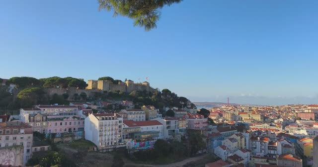 Lisbon rooftops below the castle walls, the river beyond